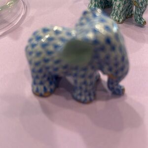Small blue elephant with tusk downward